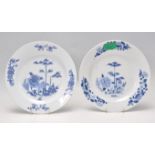 A pair of Chinese 18th Century blue and white plates of round form being hand painted with peonies
