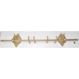 An antique style 20th Century brass curtain pole having horse head ends with the mouths supporting
