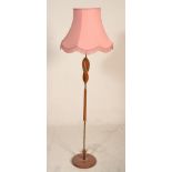 A good vintage retro 20th Century teak and brass column standard lamp raised on a circular base with
