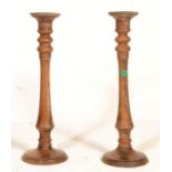 A pair of 20th Century large wooden candlesticks raised on round bases with tapering columns and