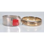 Two silver bangles to include an English hallmarked bangle with a hinge opening and engraved