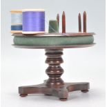 A 19th Century Victorian mahogany bobbin stand having a rotating round top with stands to each,