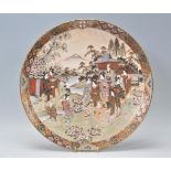 A decorative large Japanese Satsuma charger with hand painted and enameled landscape garden scene