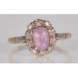 A antique 18ct gold and platinum ladies dress ring set with a central oval cut pink stone having a