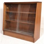 A mid century teak wood G-Plan - Ernest Gomme sliding glass bookcase cabinet being raised on a