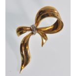 An 18ct gold vintage 20th Century 18ct gold bow brooch set with three round cut diamonds to the