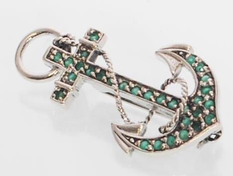 A sterling silver brooch in the form of an anchor set throughout with round cut emeralds. Gross