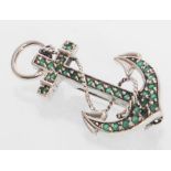 A sterling silver brooch in the form of an anchor set throughout with round cut emeralds. Gross