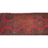 An early 20th century Persian / Islamic Bokhara rug having a red ground with multiple medallions