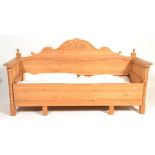 A large 20th century Scandinavian pine day bed with show wood frame and upholstered daybed centre
