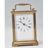 An English 20th century brass carriage clock having scrolled handle to the top with open window
