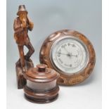 An early 20th Century carved oak barometer of circular form having a silvered dial. Together with