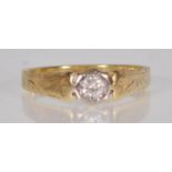 An 18ct yellow gold ladies ring set with a central round cut white stone having engraved