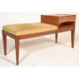 A mid century teak wood telephone table raised on square tapering legs with seat and drawer.