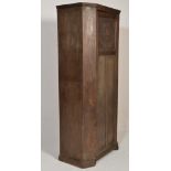 A 1920's carved oak hall cupboard wardrobe in the Jacobean revival style. Raised on a plinth base
