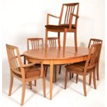 A mid century teak wood extending dining table and 6 chairs, the table raised on tapering legs
