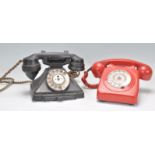 Two vintage 20th Century ring dial telephones to include a black bakelite example and a red