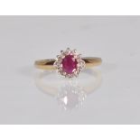A hallmarked 9ct gold diamond and garnet flower head ring having a central faceted red stone with