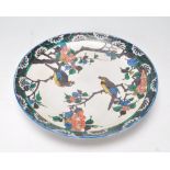 A 19th Century Chinese ceramic plate hand enamelled with birds perched on trees interspersed with