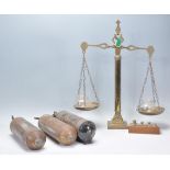 A set of brass antique balance scales raised on a columnal stand with face masks to the arms,