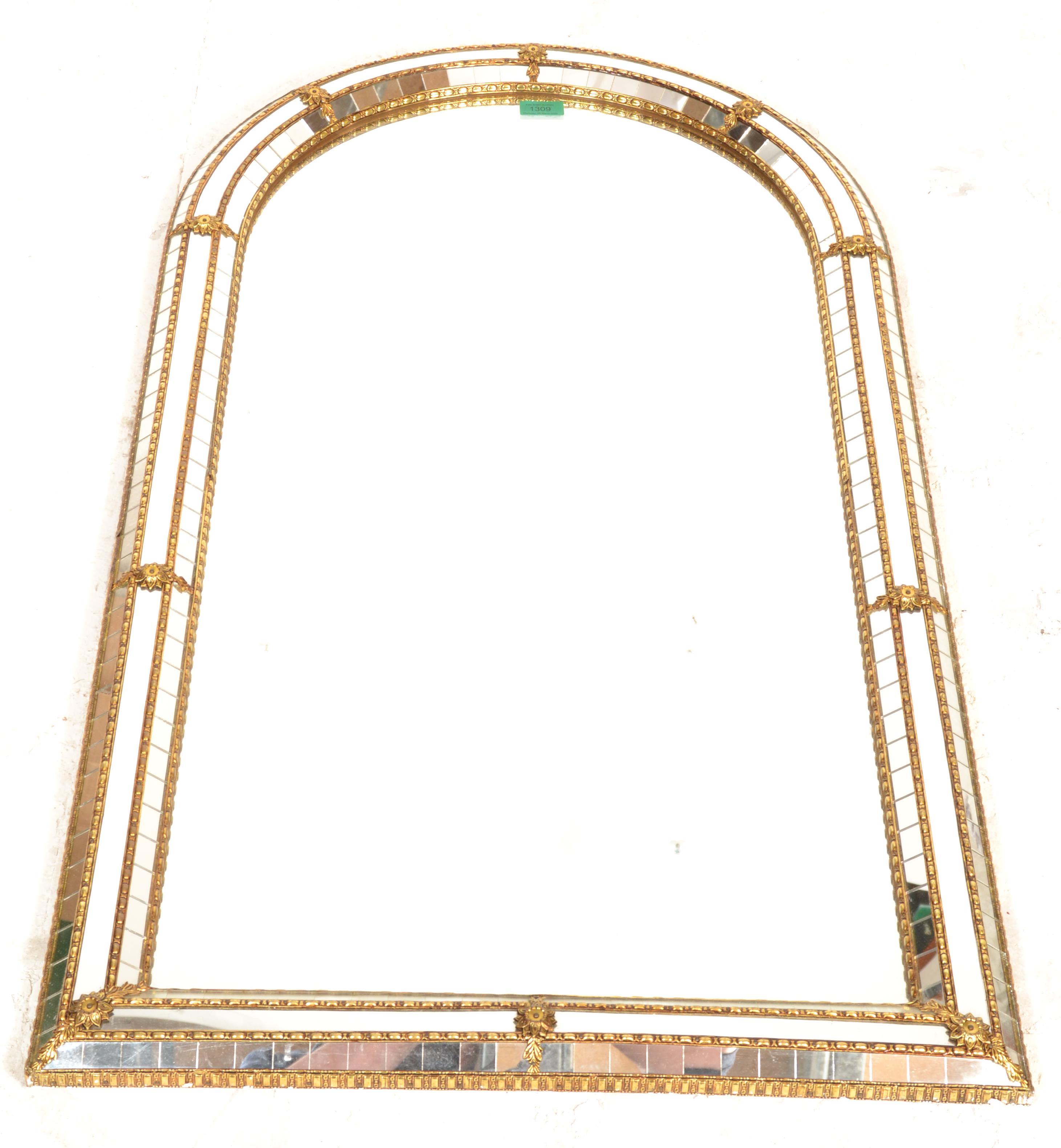 A 20th century Venetian gilt mirror of arched form with cushion border adorned qwith multiple mirror