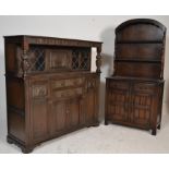 A 20th century Priory dark oak Dutch dresser with arched plate rack over drawers and cupboards to