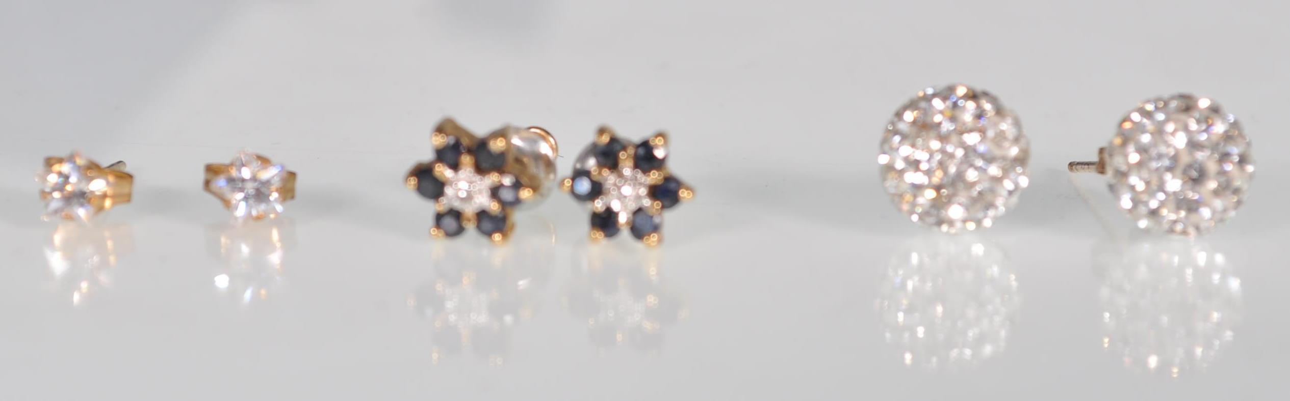 A group of three pairs of 9ct yellow gold earrings to include a pair of star cut white stones,