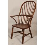 A 19th century beech and elm wood Windsor chair / armchair. Raised on turned legs united by