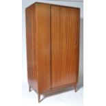 A mid century teak tambour fronted single wardrobe being raised on tapering legs with upright body