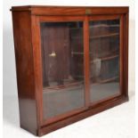 A Victorian 19th century mahogany library bookcase cabinet raised on a plinth base with twin sliding