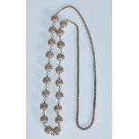 A 20th Century silver necklace having spaced filigree design beads and woven necklace chain.