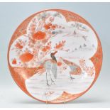 A 19th century Japanese Kutani bowl charger with scenes of storks within foliate having ochre red