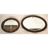 A vintage 20th Century oval oak framed mirror with carved decoration a single beveled edge