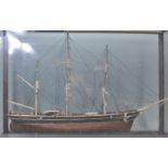 A late 19th Century glass cased, wooden built model boat. The oak case having four glass panels