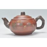 A Chinese Yixing teapot having bamboo style handles and spout, the body having raised applied floral