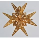 An unmarked 18ct gold filigree brooch in the form of a maltese cross with pendant bale to the verso.