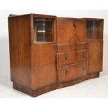 A 1950's walnut Art Deco cocktail cabinet being raised on a plinth base with end cupboards having