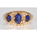 An 18ct yellow gold ladies dress ring set with a central oval faceted cut sapphire flanked by two