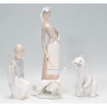 A group of three Lladro ceramic figurines to include a polar bear, a figure of a young boy and