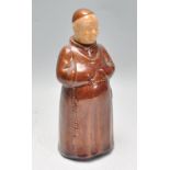 A vintage 20th Century glazed stoneware flask in the form of a monk wearing a brown robe. The head