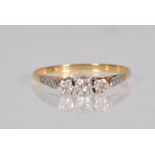 A stamped 18ct gold ring set with three round cut diamonds in a platinum setting faceted illusion