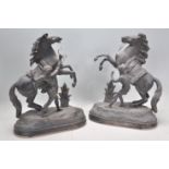 A pair of 20th Century antique style cast metal horse figurines modelled as rearing horses on