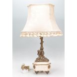 An Edwardian marble and gilded brass table lamp. The marble trefoil base with pad brass gilded