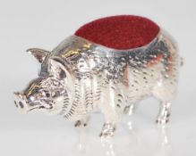 A silver pin cushion in the form of a pig with red