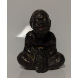 An early 20th century cast iron Black Americana paperweight / figurine of a seated male figure being