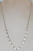 A ladies silver necklace featuring twelve oval opa