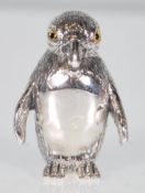 A silver figure of a penguin with engraved detail