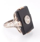 An 18ct white gold onyx and diamond ring. The ring