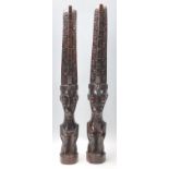 A pair of 20th Century carved dark wood African tribal figurines in the form of stylised crouched