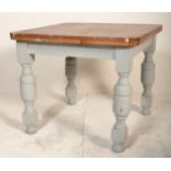 An early 20th Century oak draw leaf dining table raised on cup and cover supports united by